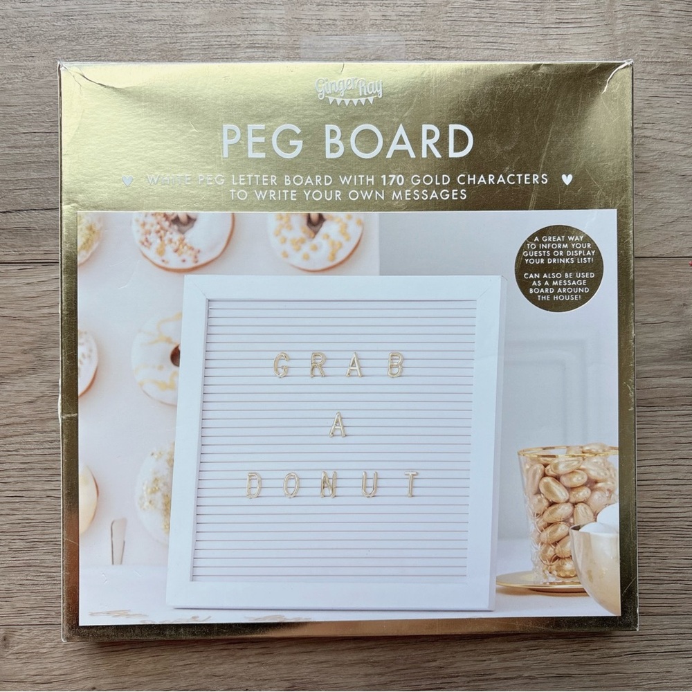 White peg letter board with gold characters